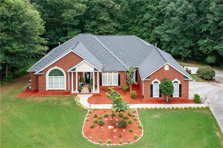 Brick facade residence with a gray shingle roof