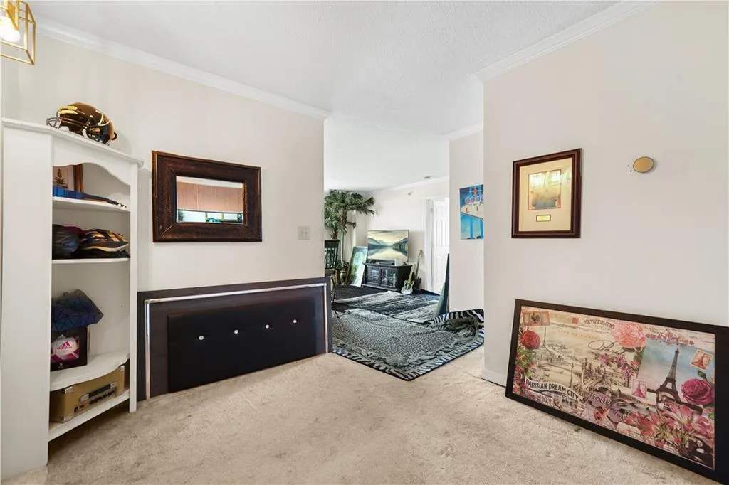 Hallway with crown molding and carpet flooring