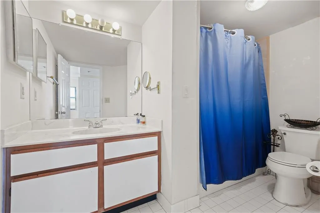 Bathroom featuring light tile patterned flooring, vanity, and a shower with shower curtain