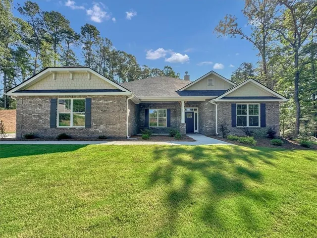 Brick exterior with gabled roofs, decorative gables, dark shutters, and a covered entry