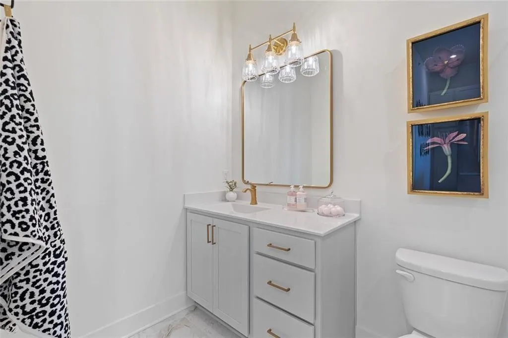 Full bath featuring vanity and marble look tiles