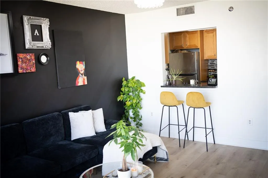Living area with light wood-style floors and a textured ceiling