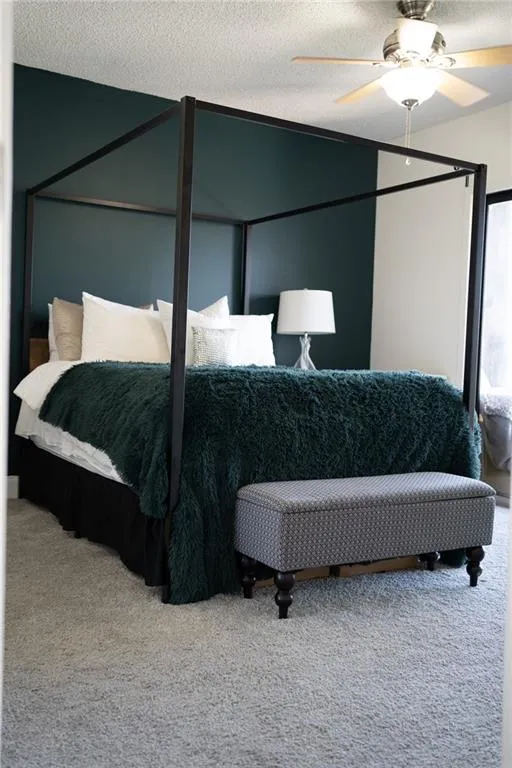 Carpeted bedroom with a textured ceiling and ceiling fan