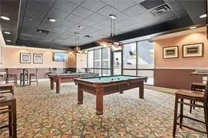 Clubroom/Amenity lounge with a drop ceiling, billiards, and a wainscoted wall