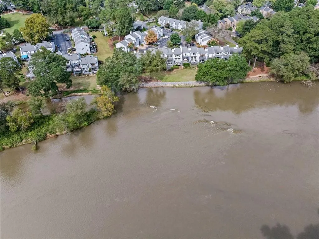 Aerial overview of property's location with a large body of water and a tree filled landscape