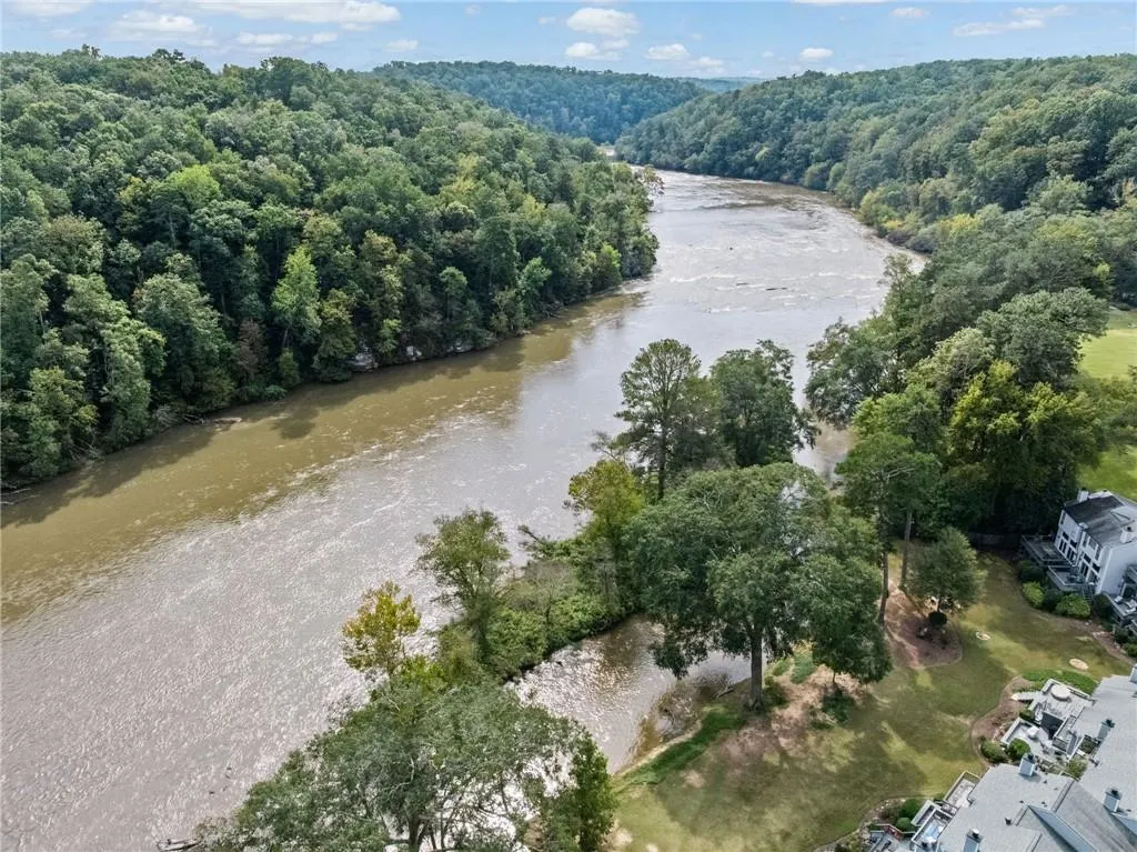 Drone / aerial view of a large body of water and a forest
