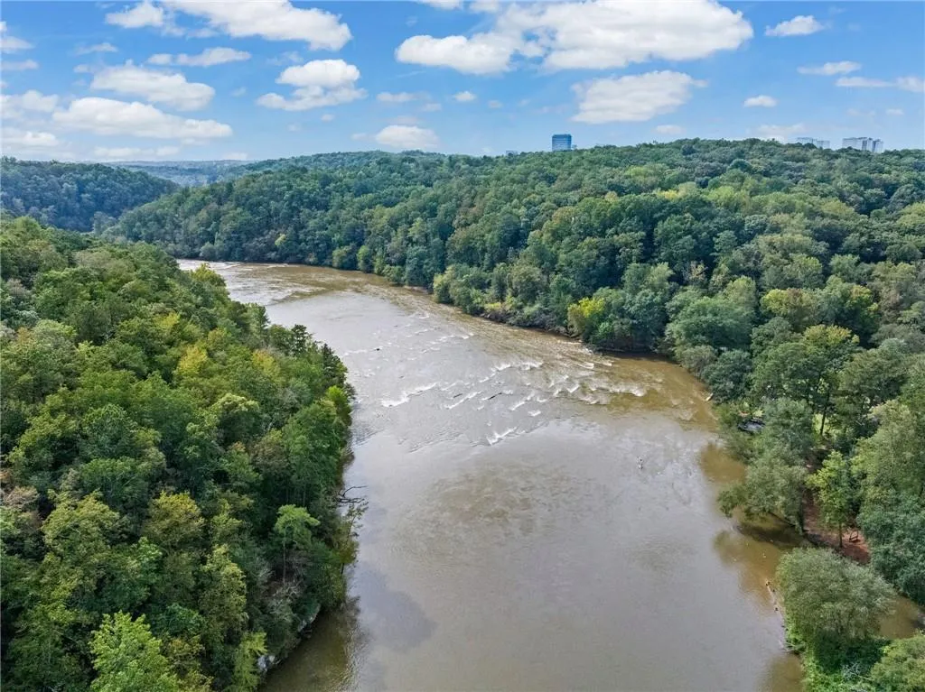 Aerial view of a nearby body of water and a heavily wooded area