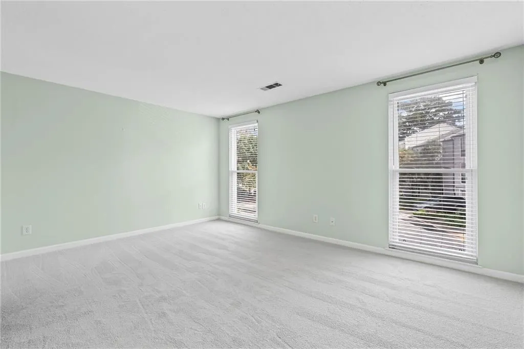 Spare room featuring light carpet and baseboards