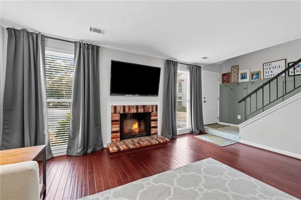 Living area featuring stairway, dark wood-style floors, and a fireplace