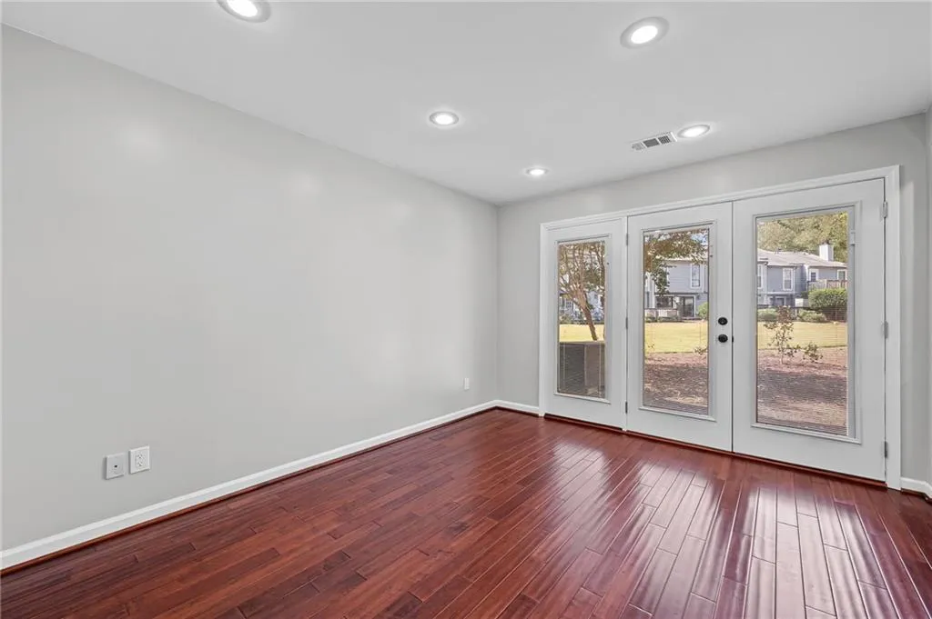 Unfurnished room featuring french doors, dark wood-type flooring, and recessed lighting