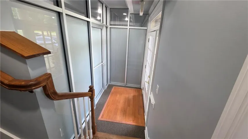 Architectural glass paneling, wood-finish flooring, and a traditional wood handrail