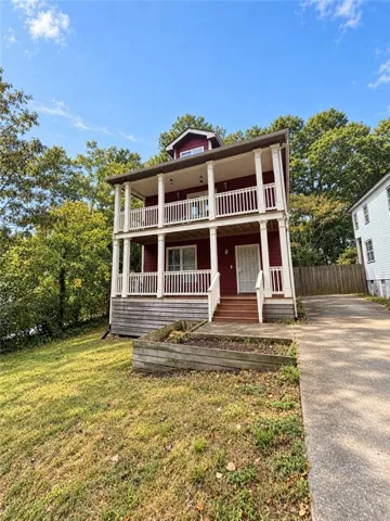 Two-story exterior with dual balconies, columned supports, and a dormer window