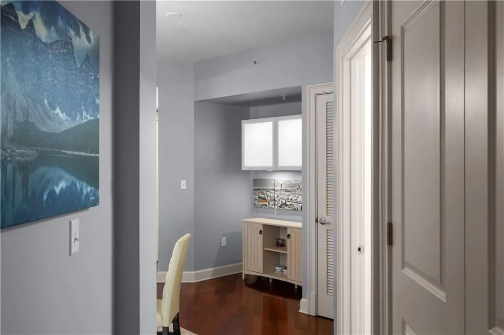Hall with an office area and dark wood-type flooring