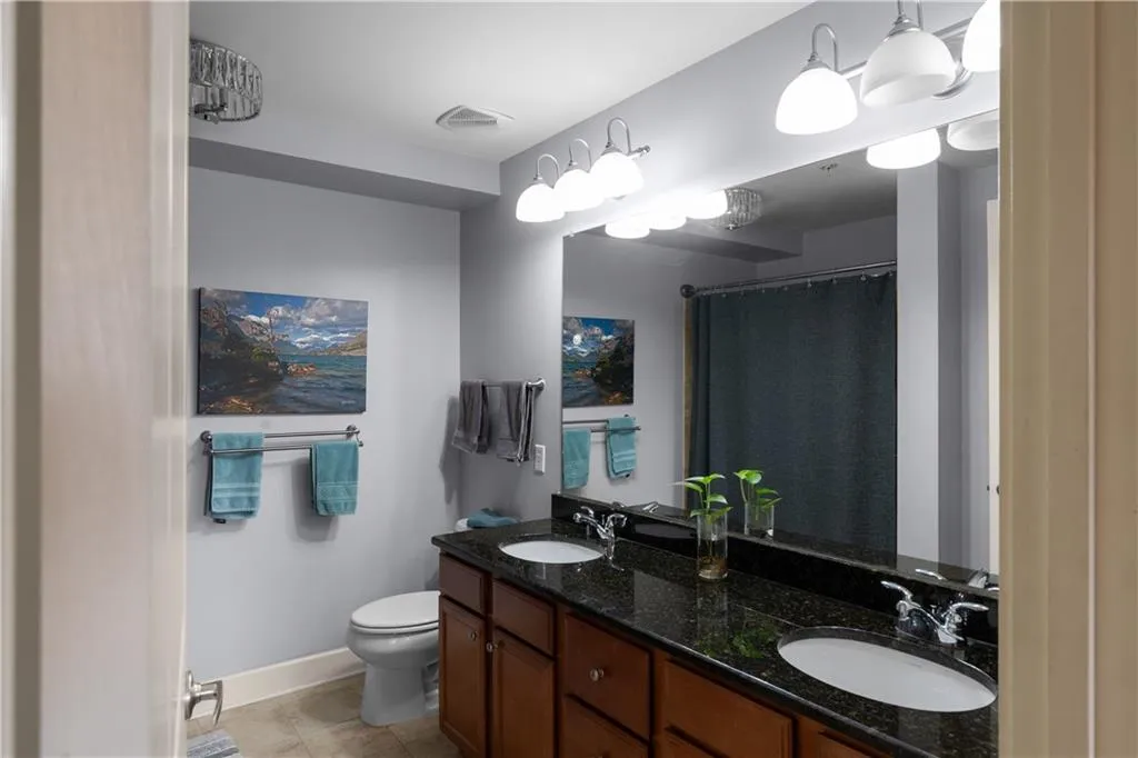 Bathroom featuring double vanity and a shower with shower curtain