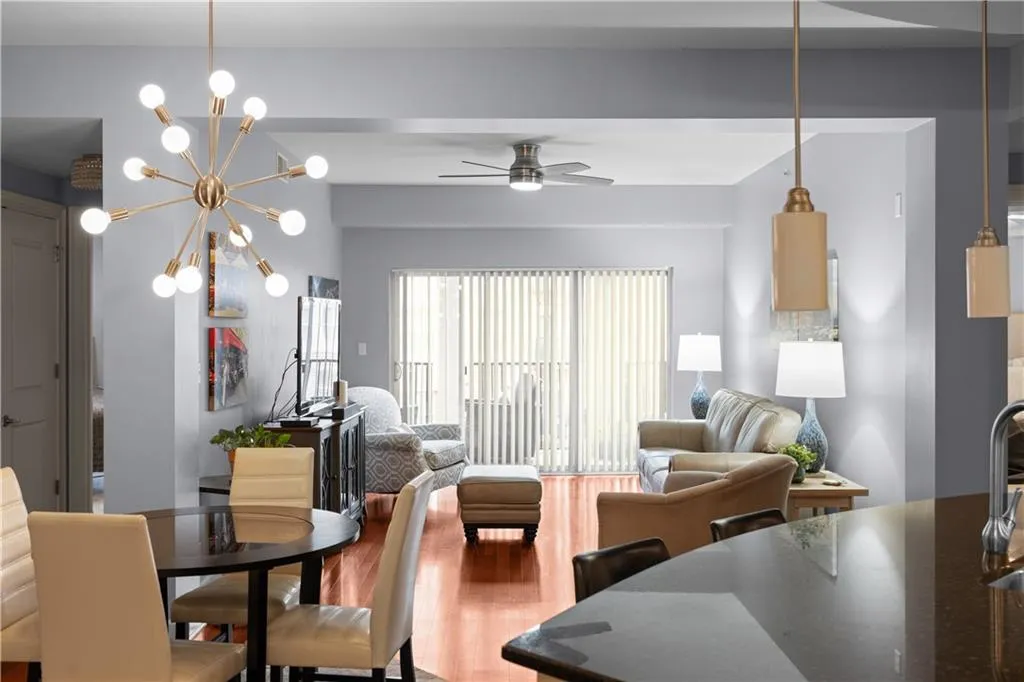 Dining space with wood finished floors, a ceiling fan, and a chandelier