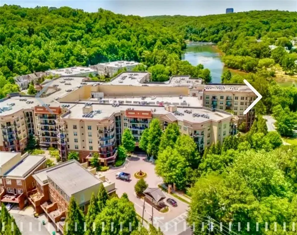 Aerial view of a heavily wooded area and apartment complex / building