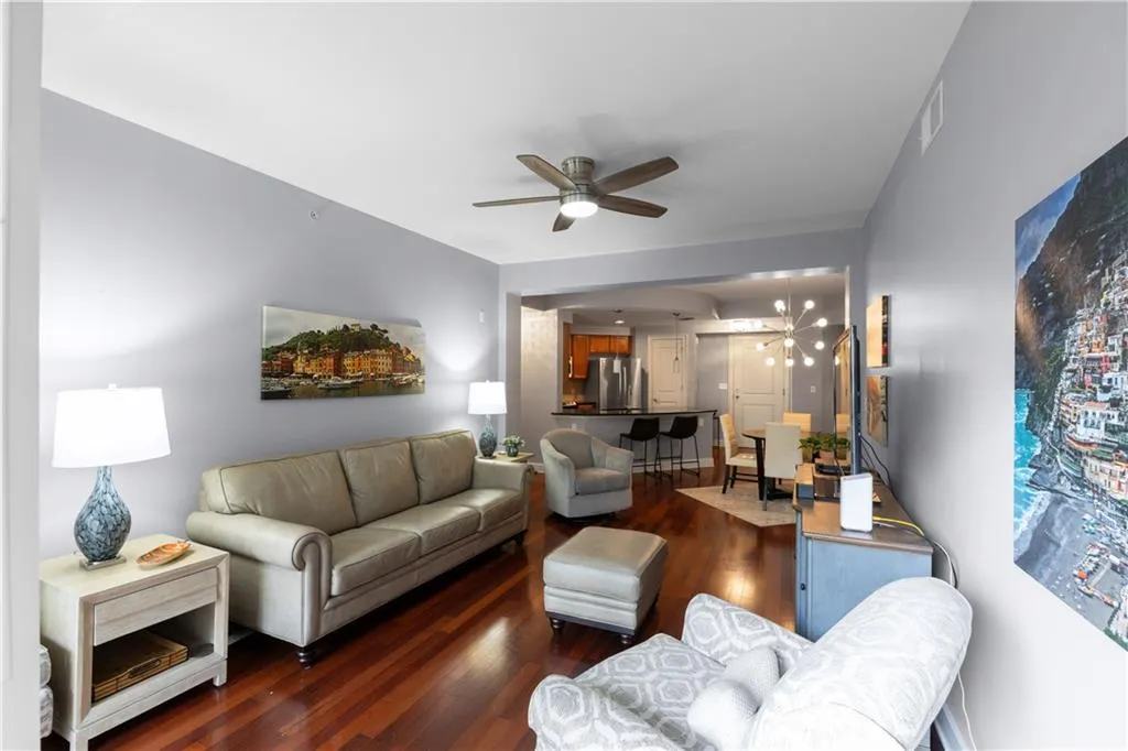 Living room featuring a ceiling fan and dark wood-type flooring