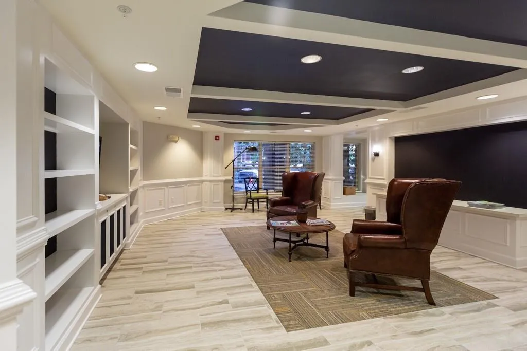 Sitting room with a tray ceiling, a decorative wall, and recessed lighting