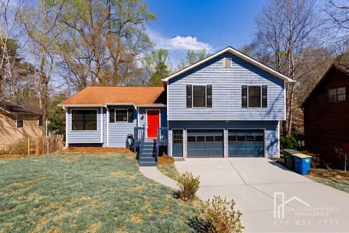Siding exterior with a two-car garage, concrete driveway, and covered entry