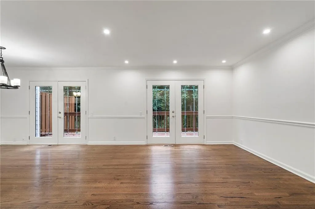 Family room open to patio and kitchen features french doors, hardwood floors and new recessed lighting