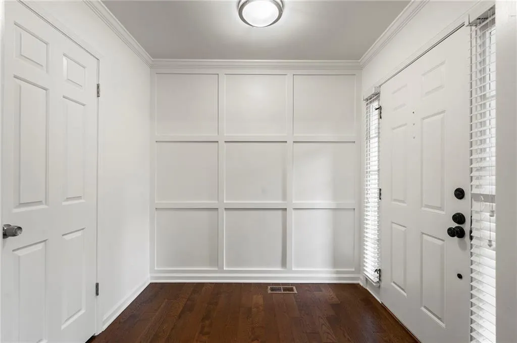 Light filled Foyer welcomes your guests with a modern accent wall, hardwood floors a large coat closet.
