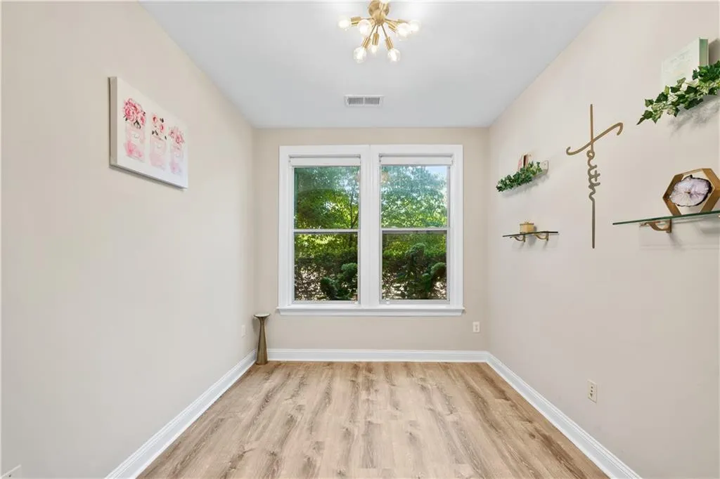 second bedroom, office or flex space with floating shelves and natural light