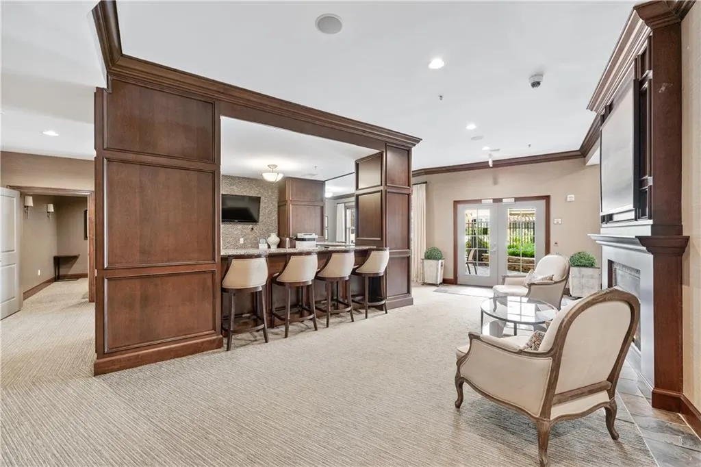 Club room featuring light carpet, recessed lighting, french doors, crown molding, and dark brown cabinetry