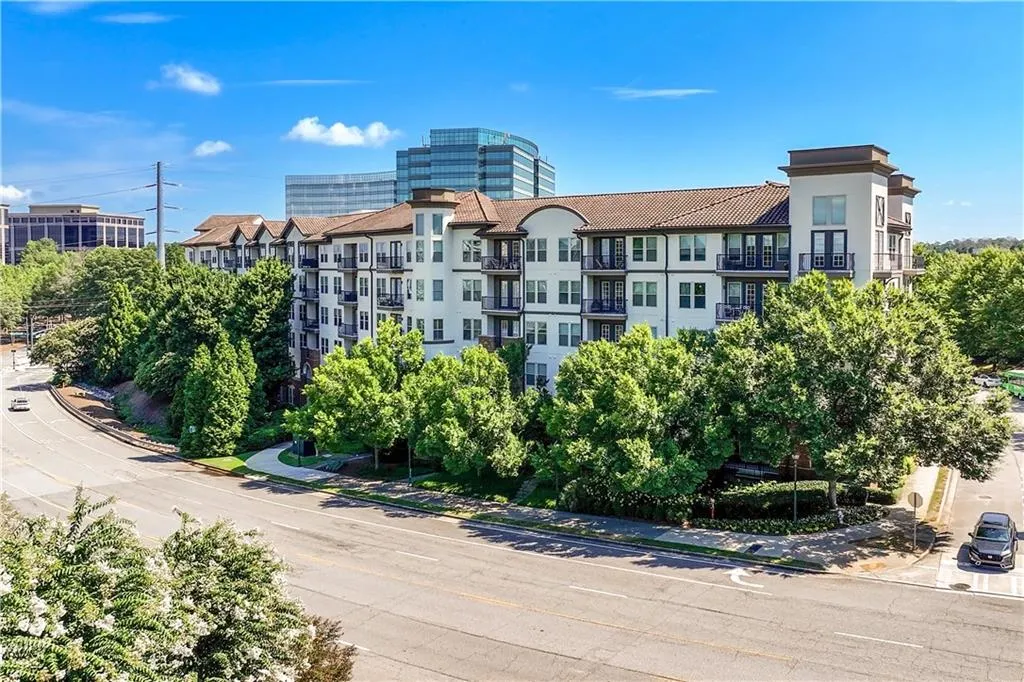View of apartment building / complex on tree lined street