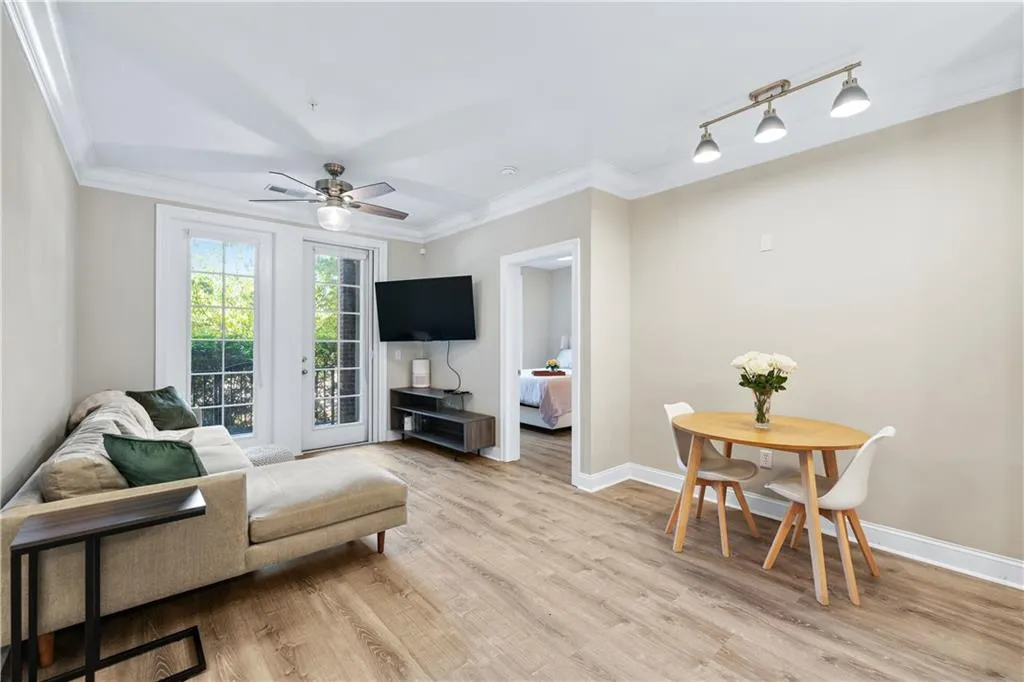 Living area featuring light wood-type flooring, crown molding, a ceiling fan, and rail lighting