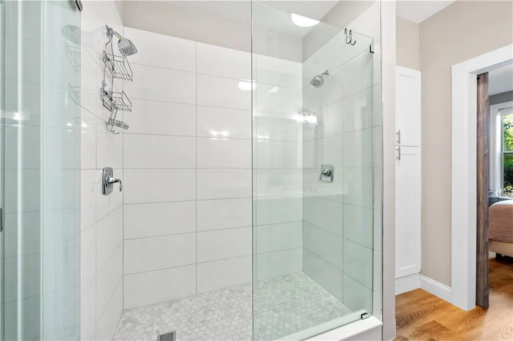 Ensuite bathroom with a shower stall and wood finished floors