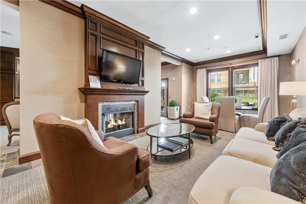 Club room living area with a premium fireplace, recessed lighting, ornamental molding, and light carpet