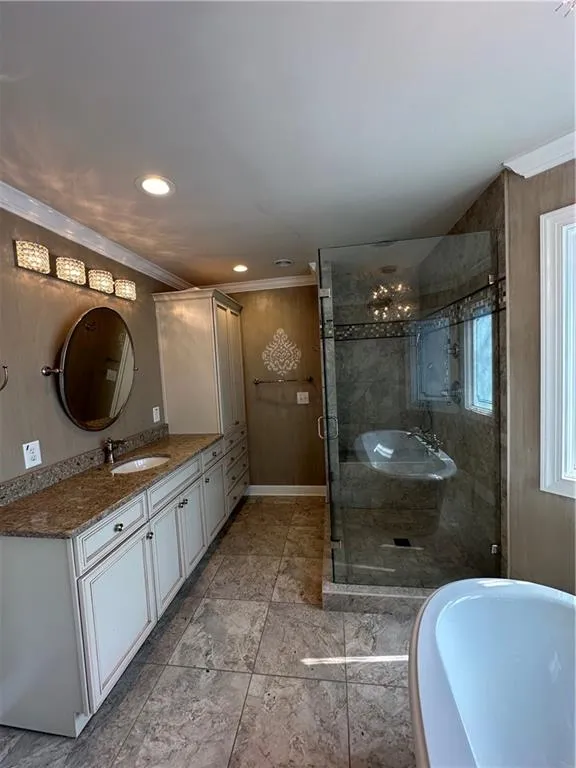 Bathroom with vanity, crown molding, recessed lighting, and a shower stall