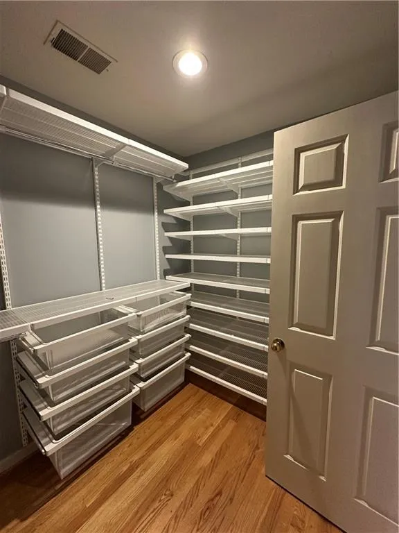 Walk in closet with light wood-style floors and visible vents