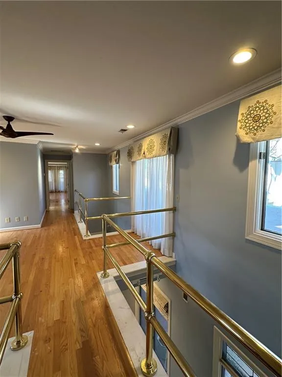 Hallway featuring an upstairs landing, ornamental molding, recessed lighting, light wood-style floors, and baseboards