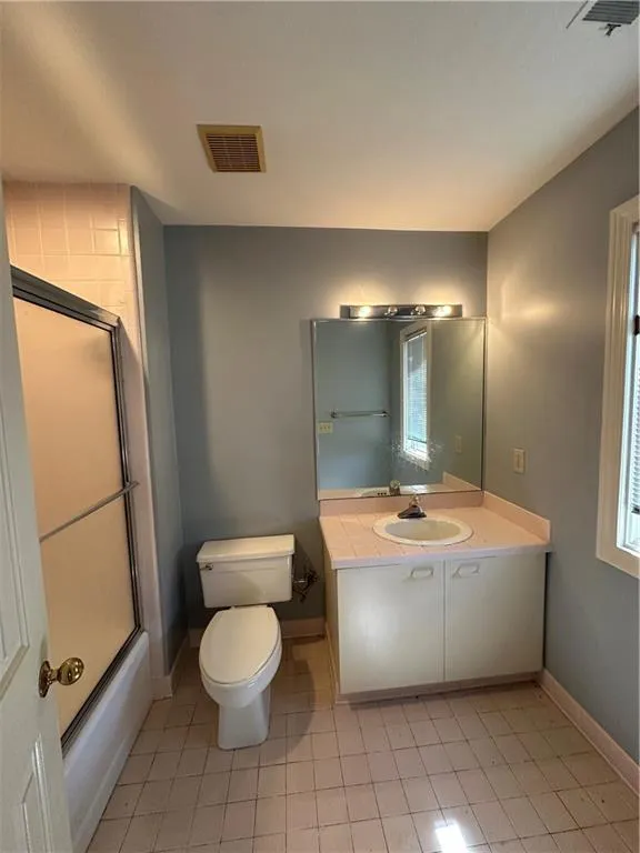 Full bath featuring visible vents, toilet, vanity, and baseboards