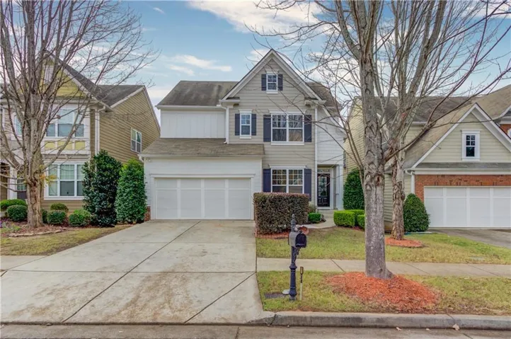 Two-story residence featuring a dual garage, concrete driveway, and front landscaping