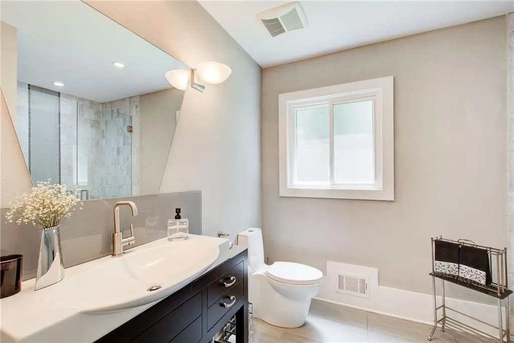 Main floor full guest bath with decorator tile and vanity.