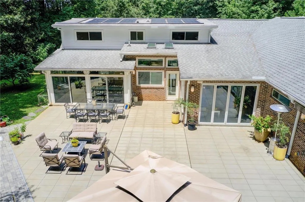 Spacious patio and partial view of level side yard for play and pets. Large fenced area for safety in pool area. Solar panels can't be seen from the ground and provide heating for the pool.