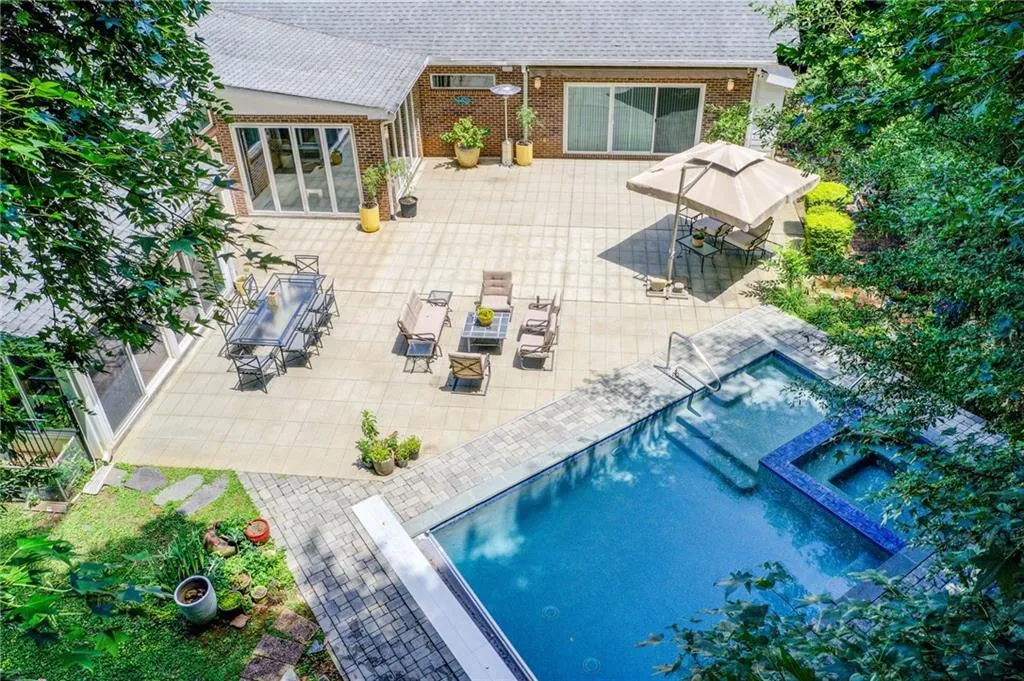 Back of house with a wall mounted air conditioner and a patio