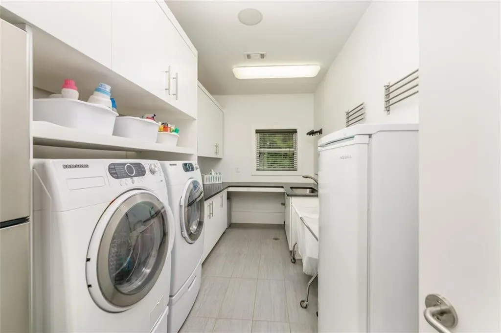 Main floor huge laundry with sink, room for freezer and lots of Costco storage. There is even a floor drain and racks for drip drying