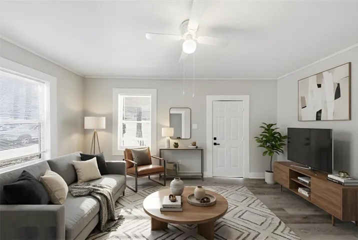 Living room with wood finished floors, a ceiling fan, and crown molding