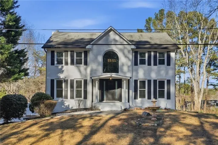 Traditional-style exterior with a gabled roofline and an arched window above the entry