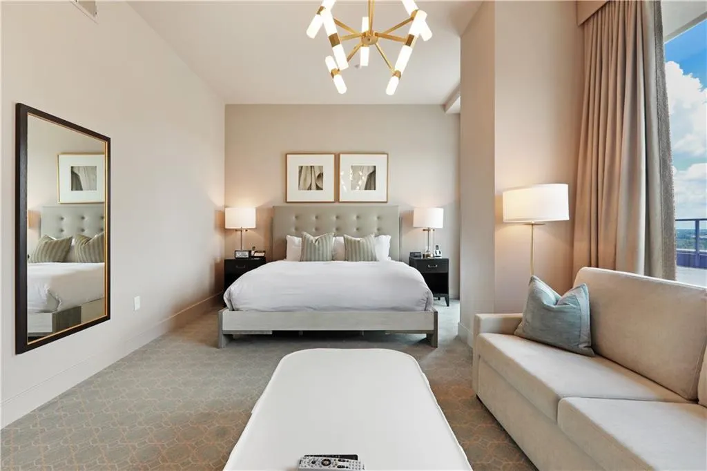 Bedroom with multiple windows, a chandelier, and carpet