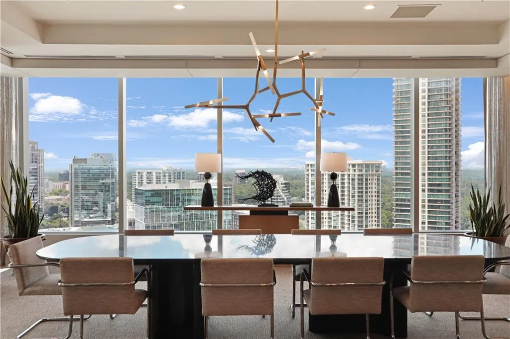 Carpeted dining room featuring a city view, a chandelier, and expansive windows