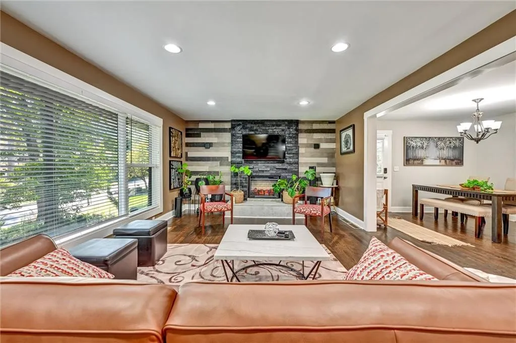 Living room with a notable chandelier, a fireplace, and dark wood-type flooring