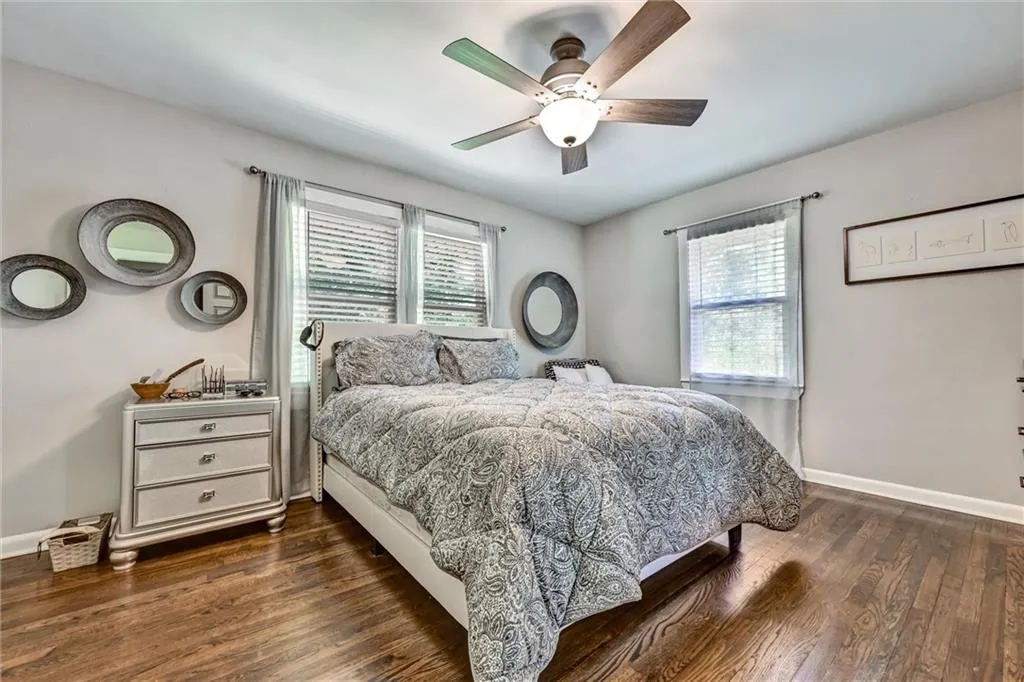 Bedroom with ceiling fan and dark wood-type flooring