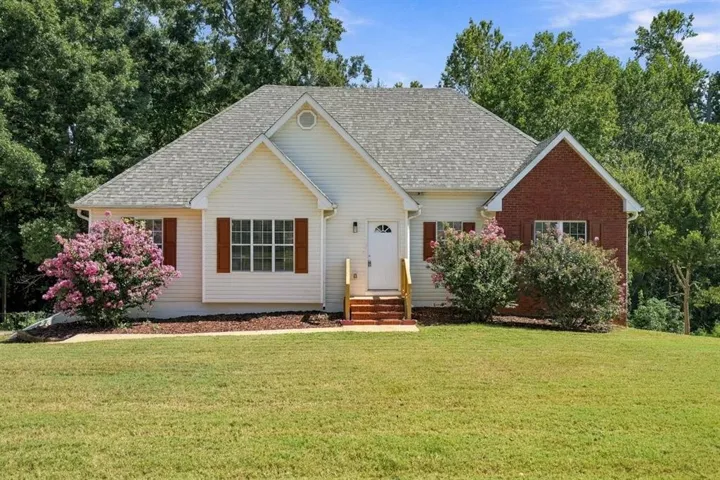 Siding exterior with brick accents, multi-pane windows, and wooden shutters