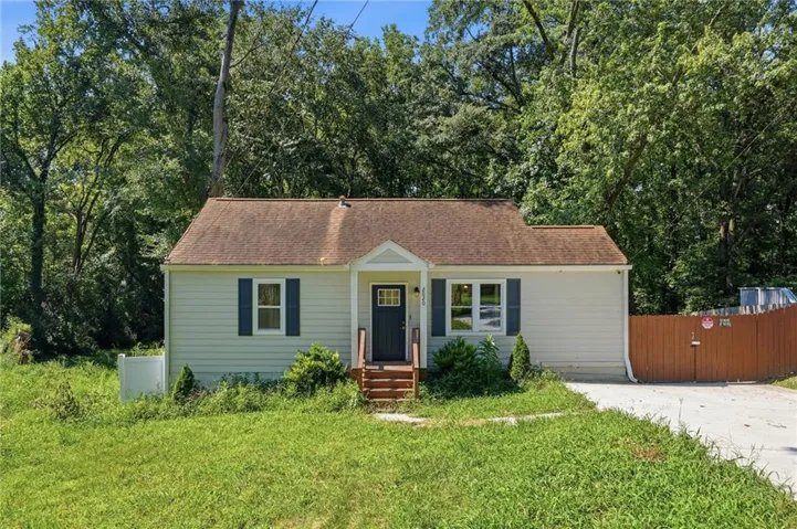 Gable roofline, light-colored siding, dark shutters, covered entry, and wood steps