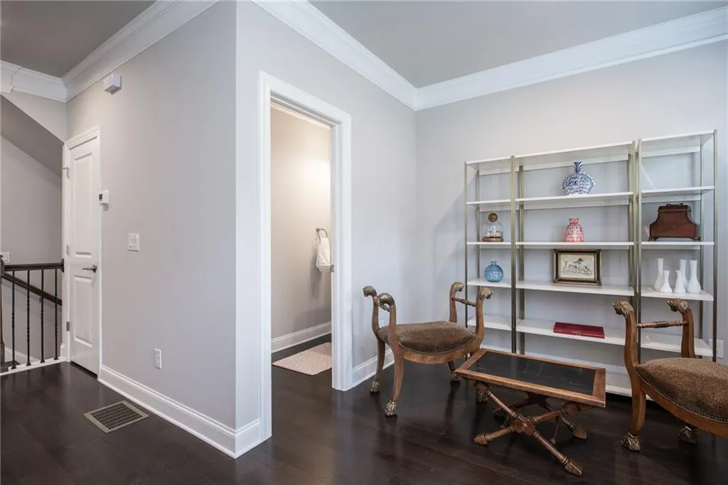 Sitting room featuring crown molding, wood finished floors, and an upstairs landing
