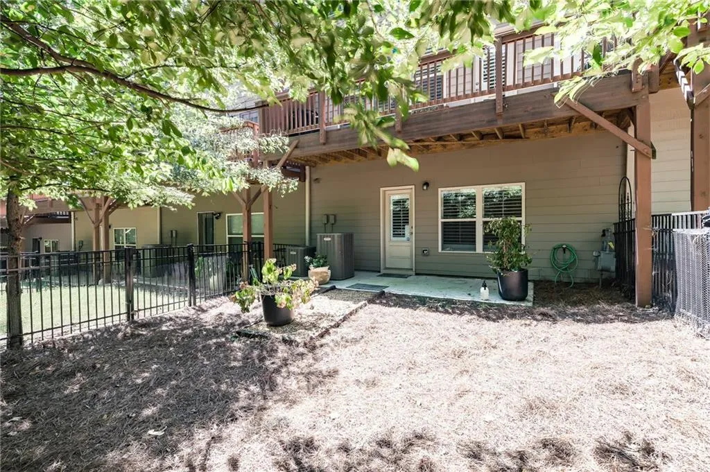 Rear view of house featuring a patio and a wooden deck